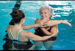 young-trainer-helping-senior-woman-aqua-aerobics-1024x680.jpg